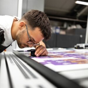 Assorted digital print materials including flyers, business cards, and packaging on a creative desk